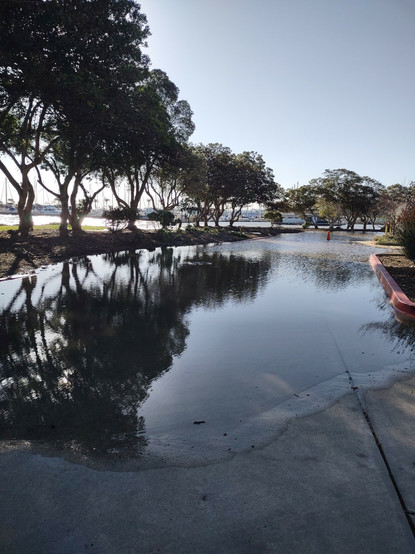 A roadway flooded by San Francisco Bay ay water during extreme king high tide.