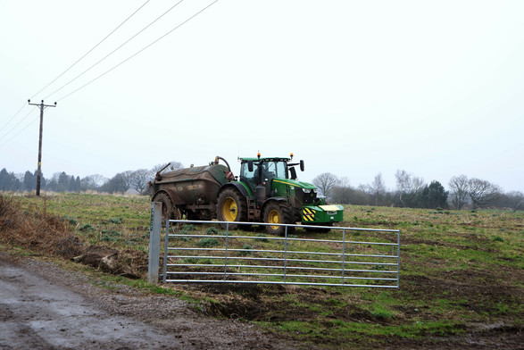 A digital colour photograph of a Farmer driving his tractor in a field.