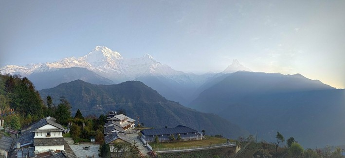 Nepali village at the bottom. Sunrise on the right. Eighthousanders in the back. Clouds slowly forming.