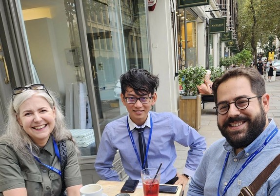 Three of us outside the cafe sitting at a table
