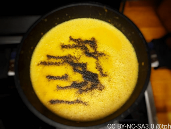 Alle Zutaten für Kürbissuppe sind püriert in einer Pfanne mit Spuren von schwarzem Pfeffer.