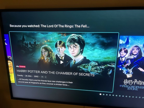 A photograph of the Now TV app on my TV reading “Because you watched: The Lord of the Rings: The Fell…” then a list of suggestions starting with Harry Potter and the Chamber of Secrets and notably not including the second Lord of the Rings film.