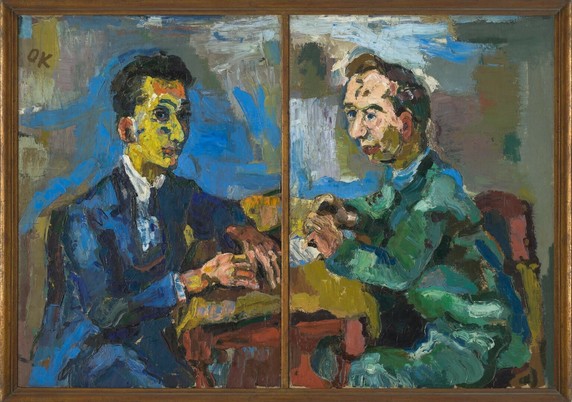 A double portrait by Oskar Kokoschka, made in 1919. On the left a man with a yellow tinted face and black hair. He wears a suit, painted in shades of blue. On the right, a man with a peach coloured face and dark brown hair. He wears a suit, painted in shades of green. The duo sits at a table, hands and arms leaning on top. The background is a jumble of blues, whites and earthen tones.