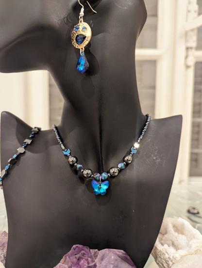 Blue butterfly set with Hematite styled beads and golden blue earrings with embedded blue gems and a beaded Hematite styled bracelet with blue beads
