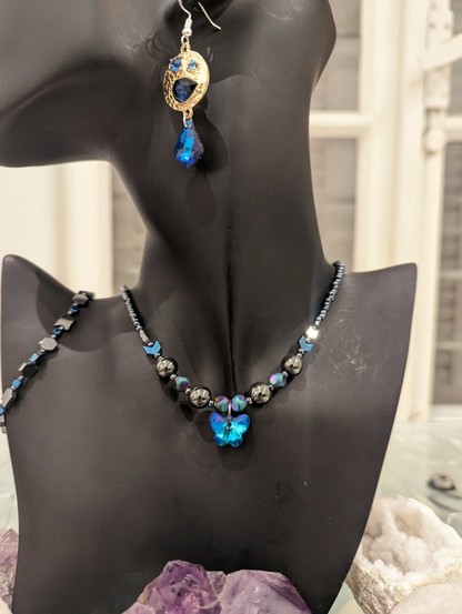 Blue butterfly set with Hematite styled beads and golden blue earrings with embedded blue gems and a beaded Hematite styled bracelet with blue beads