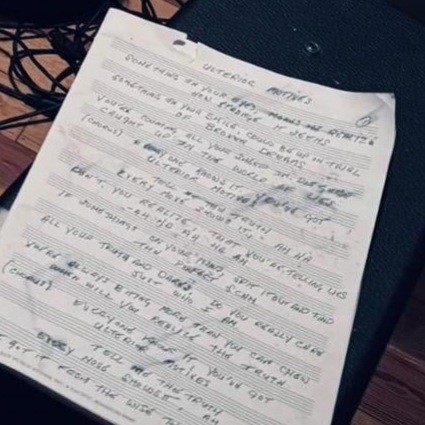 A zoomed-in picture of a sheet of music with lyrics for a song called Ulterior Motives. The lyrics read:

Something in your eyes makes me realize
How strange it seems
Something in your smile could be up in trial
Of broken dreams

You're counting all your sheep in disguise
Caught up in a world of lies

Everyone knows it 
You've got
Ulterior motives
Tell me the truth
Everyone shows it, ha-ha

Don't you realize that you're telling lies
Oh ho ah ha ah

If something's on your mind spit it out and find
The perfect scam
All your truths dares, do you even care
Just who I am

You're always biting more than you can chew
When will you realize the truth

Everyone knows it 
You've got
Ulterior motives
Tell me the truth
Everyone shows it, ha-ha