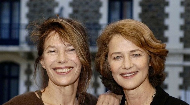 A photo of Jane Birkin and Charlotte Rampling, faces close up and they both smile happily into the camera.