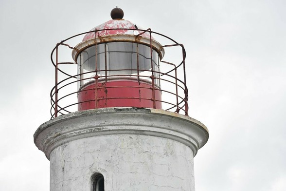 Le phare rouge est entouré de barres de fer. L'ensemble consolide la lumière permettant aux bateaux de naviguer.