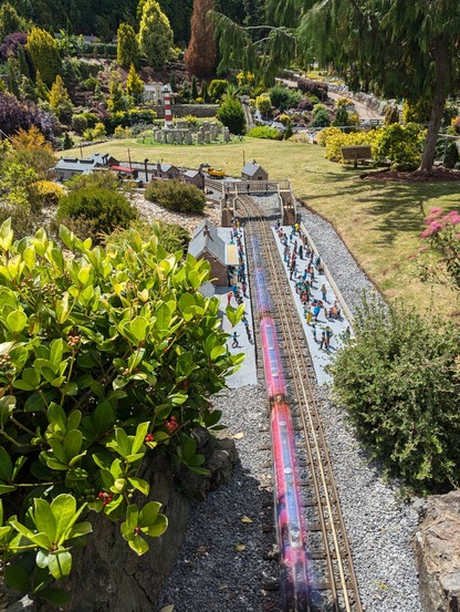 long exposure of miniature train travelling through model railway platform