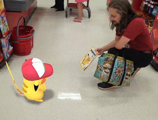 Pikachu wearing Ash's hat looking at a magazine I am holding.  The magazine is Time magazine featuring Pikachu on the cover.