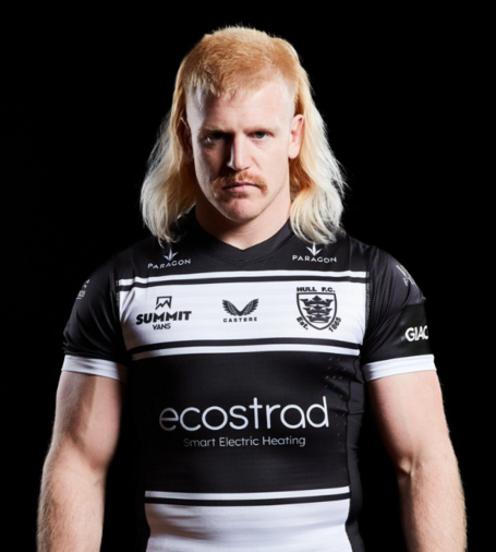 Mr Brad Fash, perpetrator of rugby league. He is wearing his Hull FC shirt and has a ridiculous blond mullet. He is trying to look all scary and intimidating, but just looks funny.