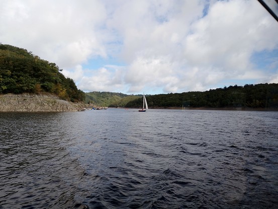 Blick vom Schiff über den Rursee, mit Segelboot