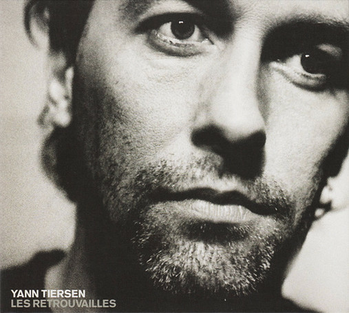The cover art is a black and white photo of the artist, a close up on his face as he looks off camera. The artist's name is in small white font in the bottom left corner, with the album name directly below in a grey font of the same size.