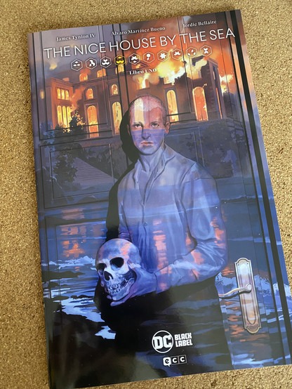 El primer número en grapa de la colección The nice house by the sea. En portada se ve a un hombre en primer plano sujetando una calavera. Al fondo, una mansión en primera línea de playa arde hasta los cimientos.