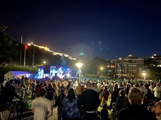 John Butler performs in front of a big crowd outside in a park at night