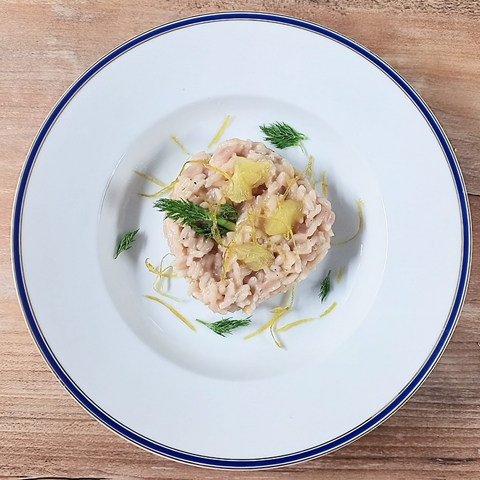 Das fertige Risotto auf dem Teller, garniert mit Fenchelgrün, Bergamottezesten und Begamottefilets
