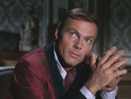 Adam West as Bruce Wayne.