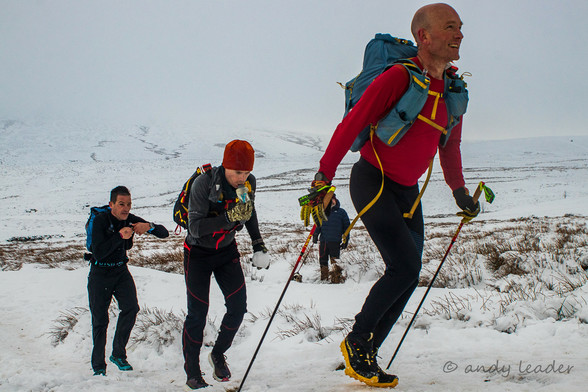 3 long distance runners in snow on the Pennine Way.
