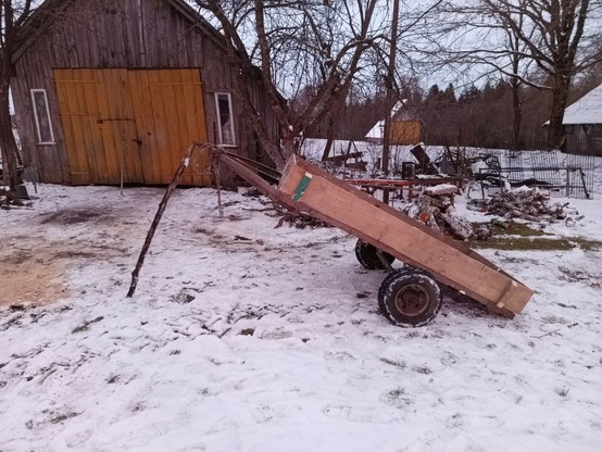 The trailer, unhitched and tilted back like a dump trailer, the hitch supported by a stick, giving me ideas for improvements.