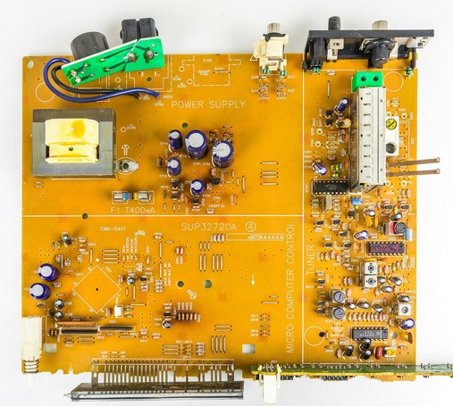 Platine in senffarben. Links oben kleine Trafo zur Stromversorgung, rechts außen der eigentliche Tuner, Display unten links