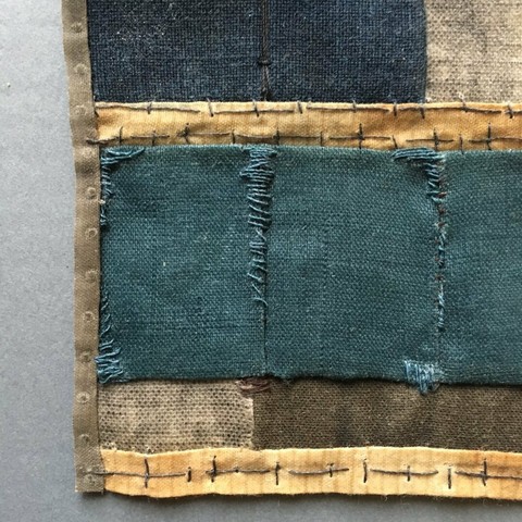 Abstract waxed fabric collage sewn with very rough stitches for texture