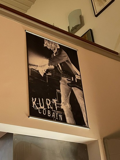 Poster on my wall: Black and while photo of Kurt Cobain on stage with both hands up the neck of his guitar.