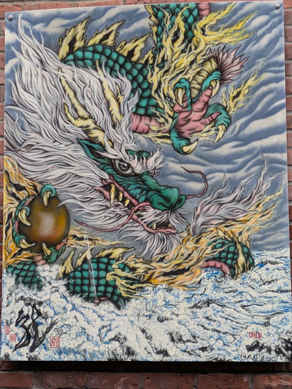 In this painting mounted on a brick wall, a green-skinned dragon with golden-yellow horns, fierce claws holding a dark fruit, yellow tufts of flame along her body, and a huge silver mane emerges from and through mountains and skies that share the silver and grey coloration of her hair.