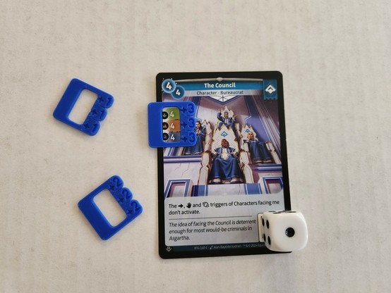 A picture of a trading card from Altered TCG that has a dice (to block a QR code) and a 3d printed plastic around some numbers at the top left. The numbers are used in the card game to keep score of who is winning. The numbers are 4/4/4 and the 3d printed part has +3/+3/+3 engraved on it, making the numbers 7/7/7.