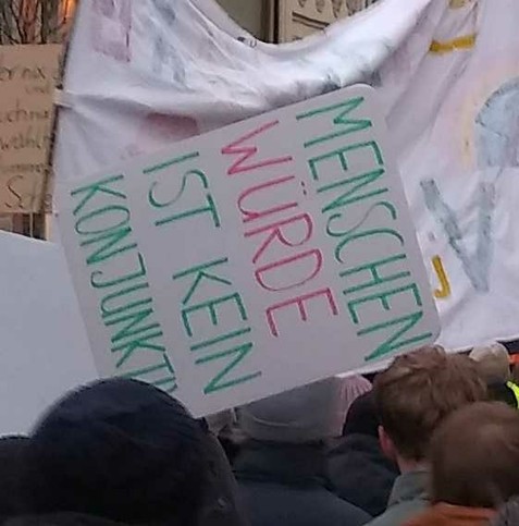 Ein Demoschild mit der Aufschrift: Menschenwürde ist kein Konjunktiv.