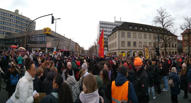 Panoramabiild der Eröffnungsveranstaltung: viele Menschen auf der Straße vor den Bahnhof in Bamberg