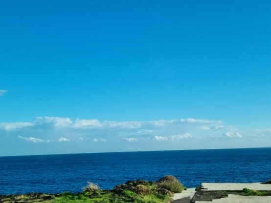 Cielo sereno dopo la pioggia, nuvole passeggere in lontananza, mare di un profondo blu