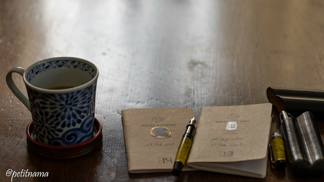A cup of coffee, two dialog notebooks and fountain pen