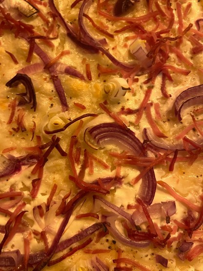 Flammkuchen mit Zwiebeln und Speck frisch aus dem Ofen.