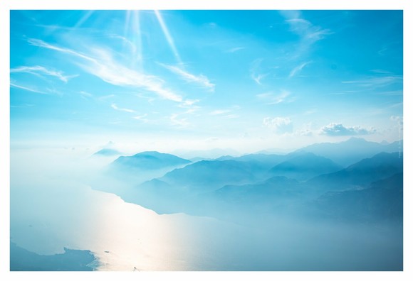 Landscape photography of a scenic aerial view of majestic mountains and serene water, showing the beauty of nature from a high perspective.