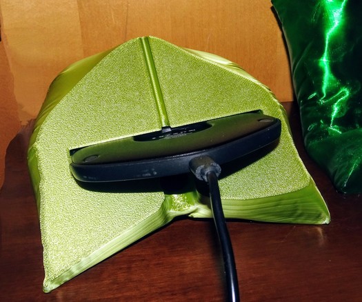 photo of the phone stand pillow from the bottom. A wireless charger (kpon invisible charger c30) is halfway slotted into the recess designed into the pillow. This photo demonstrates the easy and the howto of using a wireless charger with this phone stand