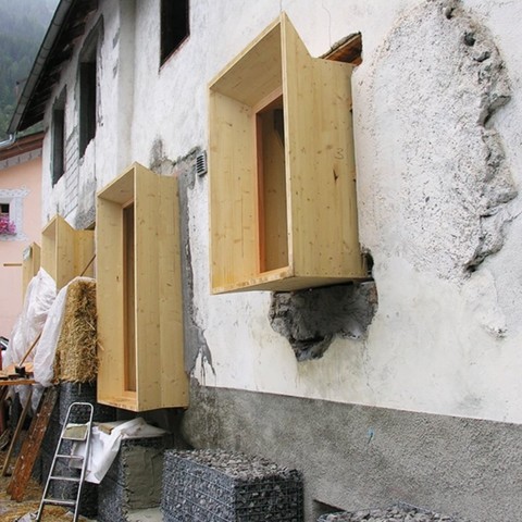 Wooden boxes with angles for more light attached to the existing wall, windows moved forward to the insulation layer.