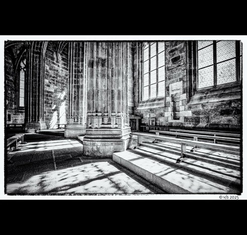 Le Mont-Saint-Michel | In der Kirche. Große Steinsäulen, rechts davon 3 Holzbänke.