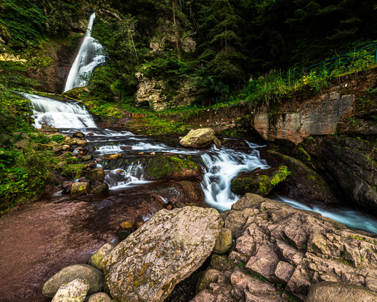 foto di una cascata con il ruscello che passa tra le rocce.
