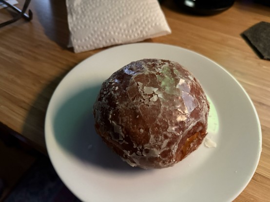 A glazed paczki on a white plate. It’s perfect