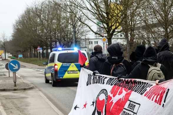 Frontblock von der linken Seite aus gesehen. Davor fährt ein Polizeiauto