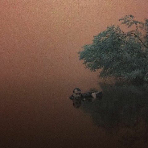 John dans son eau rouge, qui barbote de manière inquiétante.