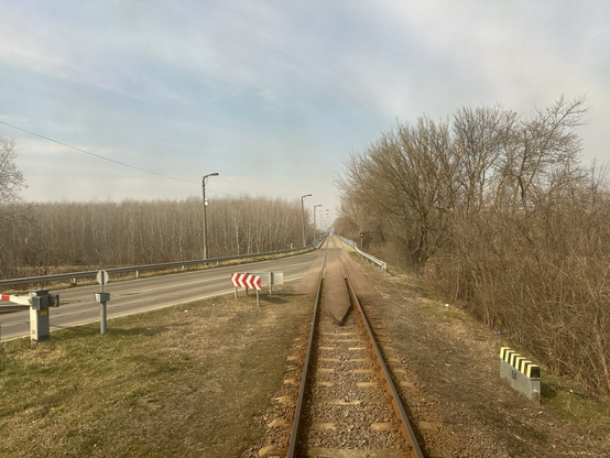 Das Gleis verlässt die Straße, links ein Schrankenbaum