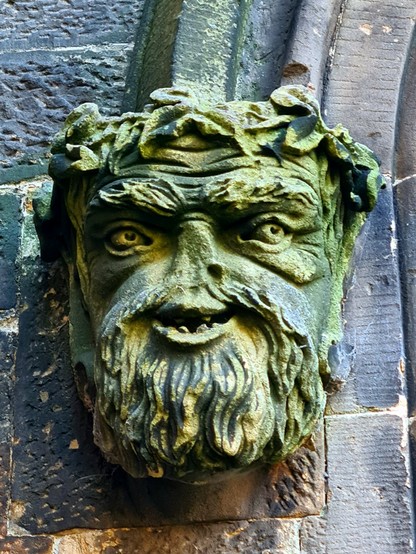 A bearded green man type head on an old Glasgow Church.