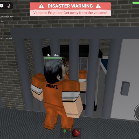 A Roblox screenshot. She’s dressed as Hannibal and I’m dressed as Will. Our body types are the blocky Roblox ones and our heads are realistic Mads Mikkelsen and Hugh Dancy faces. I’m committing cell inception (cell-ception?) I’m in a jail cell while wearing a jail cell accessory. Hannibal stands outside the cell. He’s a little too close for comfort but you know how he is