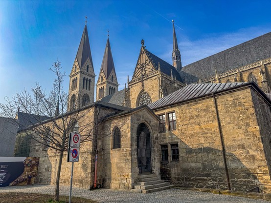 Von der Nachmittagssonne gelb angestrahlt das Gebäude (Nebengebäude und Dom zu Halberstadt), Blick von Südosten, zu sehen sind Südquerhaus, die Türme und das Klausurgebäude des Kreuzgangs, in dem die Ausstellung zum Domschatz untergebracht ist