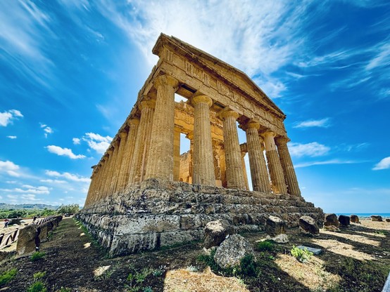 Greek temple shot from below beneath a dramatic blue sky