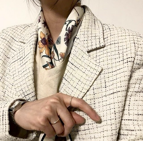 Light small-checked blazer with beige v-neck thin knitted jumper & patterned scarf in the same color scheme.