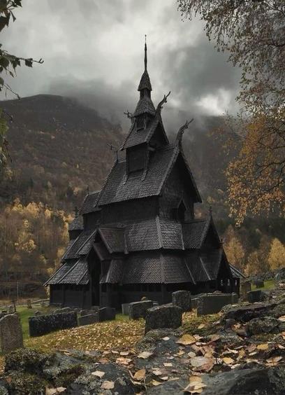 Borgund Stave Church - black wooden building surrounded by autumn landscape