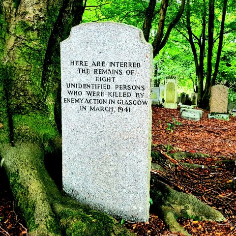 A simple gravestone inscribed with the words: Here are interred the remaina of eight unidentified people who were killed by enemy action in Glasgow March 1941.