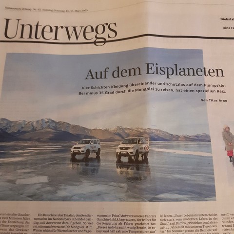Schlagzeile "Auf dem Eisplaneten". Im Foto parken zwei Toyota Prado auf dem gefrorenen See, im Hintergrund das Seeufer.